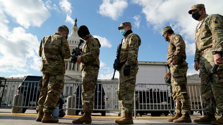 Vojáci národní gardy dostávají zbraně v Kapitolu USA, protože bezpečnostní opatření se zpřísňují před inauguračními událostmi prezidenta na Capitol Hill ve Washingtonu, USA, 17. ledna 2021. REUTERS/Erin Scott