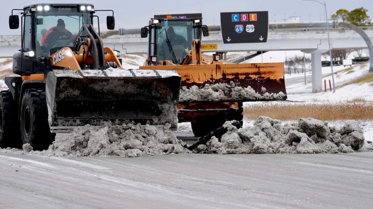 Dělníci odhrnují sníh z vozovek na uzavřeném mezikontinentálním letišti George Bushe v úterý 21. ledna 2025 v Houstonu. (AP Photo/David J. Phillip)