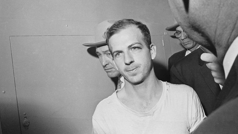 Lee Harvey Oswald je po střelbě předveden k policejnímu výslechu. Obrázek: AP