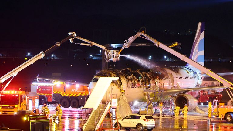 Hasiči se snaží uhasit požár na leteckém letadle na mezinárodním letišti v Gimhae v Busanu v Jižní Koreji.  Pic: Yonhap/ap