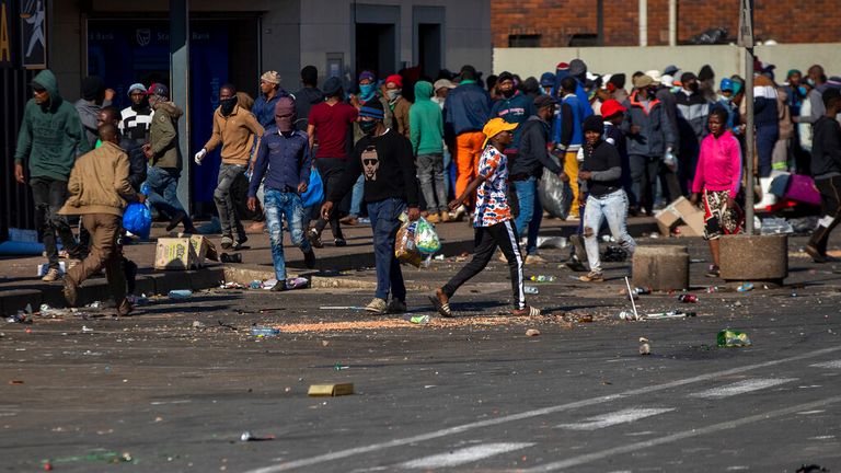 Looters nesou předměty v nákupním centru Letsoho v Katlehongu, východně od Johannesburgu