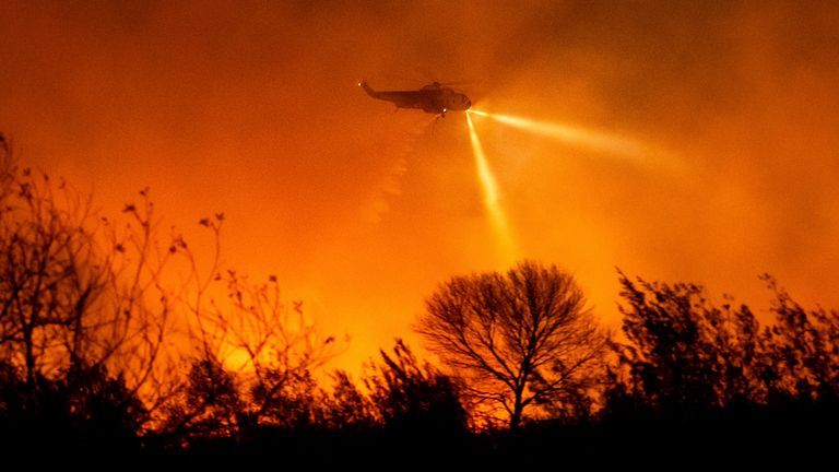 Vrtulník v pondělí 13. ledna 2025 upustil vodu při hašení požáru Auto Fire v okrese Ventura v Kalifornii. (AP Photo/Noah Berger)