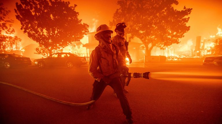 Hasiči bojují s požárem Palisades, který hoří několik staveb v sousedství Pacific Palisades v Los Angeles, úterý 7. ledna 2025. (AP Photo/Ethan Swope)