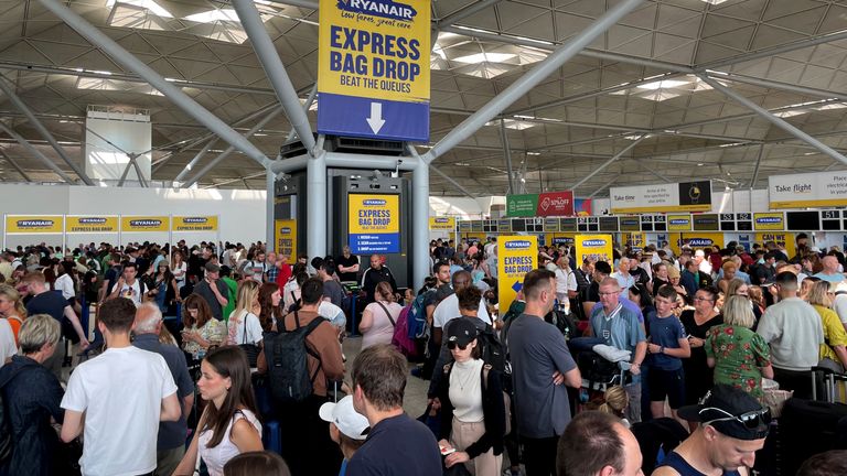 Cestující stojí ve frontě u odbavovací přepážky Ryanair na Stanstedu. Obrázek: PA