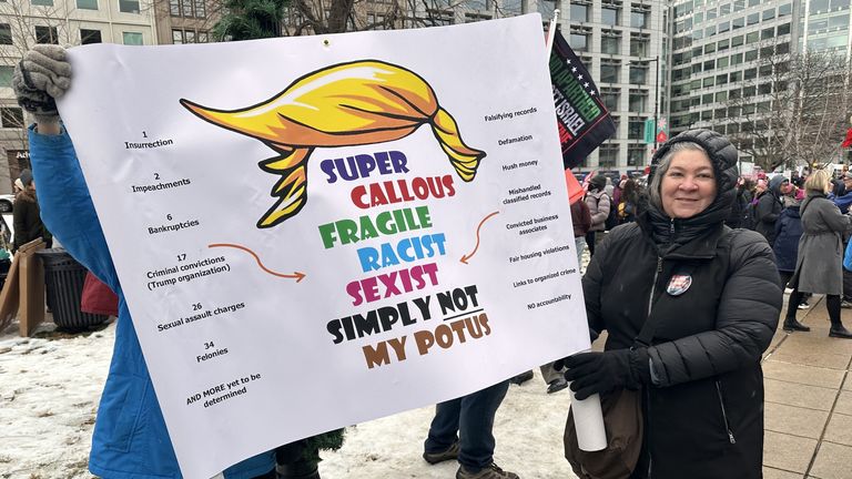 Demonstranti na sobotním Pochodu lidu drží nápis proti Trumpovi