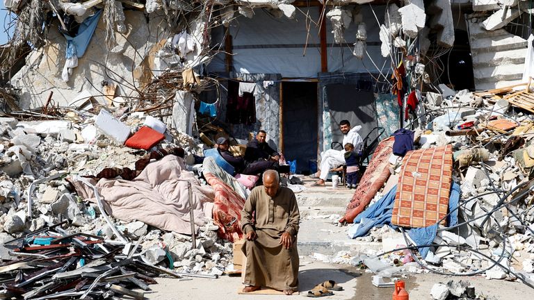 Palestinci sedí mezi troskami budov zničených Izraelem, když se politici snaží rozhodnout o osudu enklávy a její lidé se snaží žít dál.  Pic: Reuters/Hatem Khaled