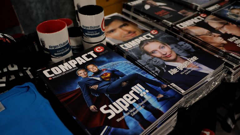 A magazine cover shows Elon Musk dressed up as Superman carrying AfD leader Alice Weidel