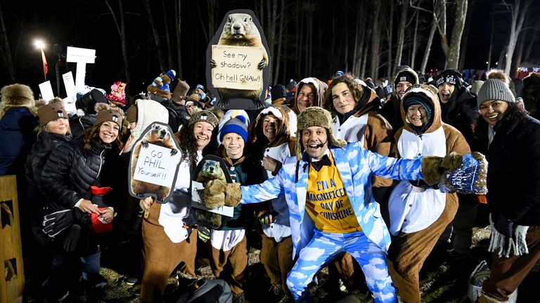 Lidé představují s viceprezidentem vnitřního kruhu Groundhog Club Dan McGinley, v den, kdy Groundhog Punxsutawney Phil předpovědí, jak dlouho bude zima během slavností Groundhog Day, v Goblerově knoflíku v Punxsutawney, Pennsylvania, USA, 2. února 2025. Reuters. /Alan Freed