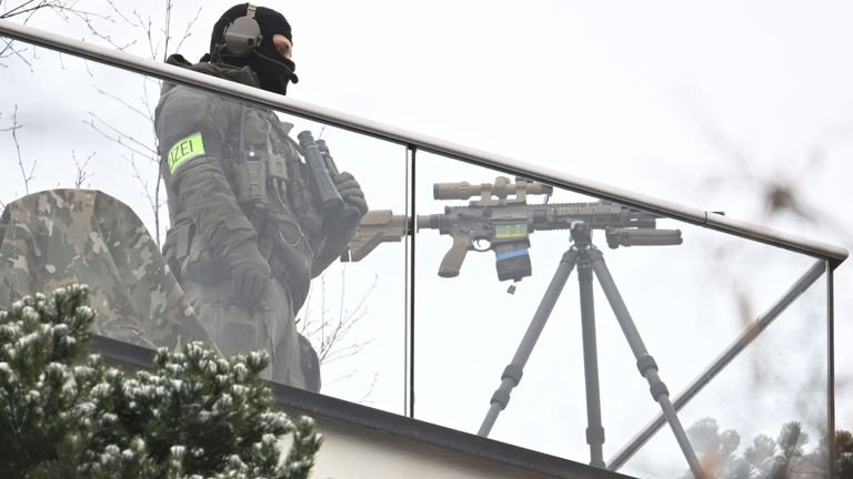 Policejní odstřelovač zajišťuje místo konání konference svou zbraní. Pic: Ap