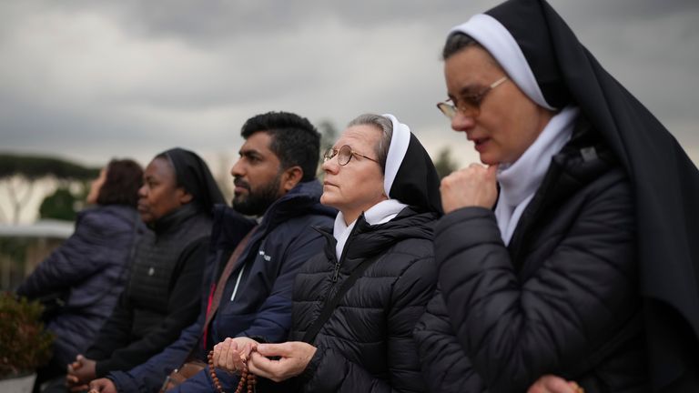 Jeptišky se modlí za papeže Františka před sochou papeže Jana Pavla II. V Agostino Gemelli Polyclinic, v Římě, ve čtvrtek 20. února 2025, kde je pontiff hospitalizován od pátku 14. února. )