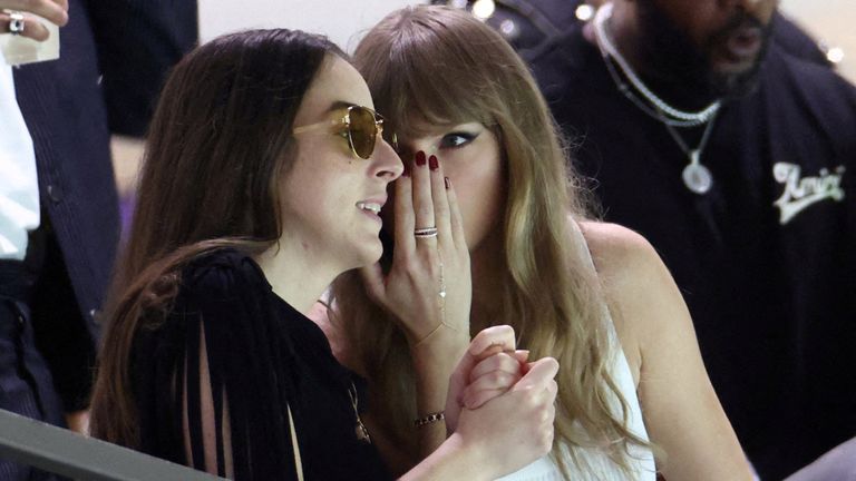 Taylor Swift hovoří s hudebníkem a herečkou Alanou Haim ve stáncích. Pic: Reuters