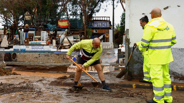 Lidé čistí bláto od silnice odplacené deštěm v sousedství Ojos de Garza v Telde na ostrově Gran Canaria ve Španělsku.  Pic: Reuters