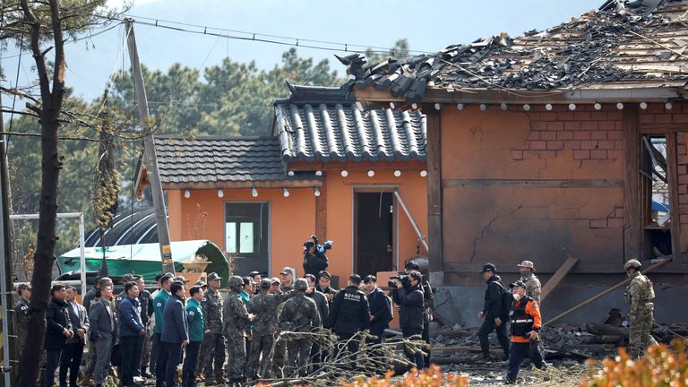 Úředníci zkoumají téměř poškozené budovy.  Pic: Reuters