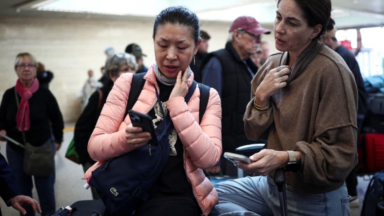 Carol Ye z Kanady zkontroluje svůj telefon, když čeká na létání do Toronta přes mezinárodní letiště Heathrow. Pic: Reuters