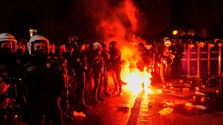 Protestující hodí světlice proti nepokojům policejních mužů během střetů na shromáždění proti zatčení starosty Istanbulu Ekrem Imamoglu, v Istanbulu, Turecko, pátek 21. března 2025. (AP Photo/Khalil Hamra)