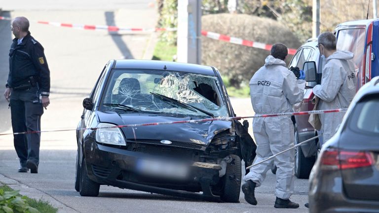 Forenzní důstojníci zkoumají poškozené auto na přístupové cestě k mostu Rýna.  Pic: DPA/AP