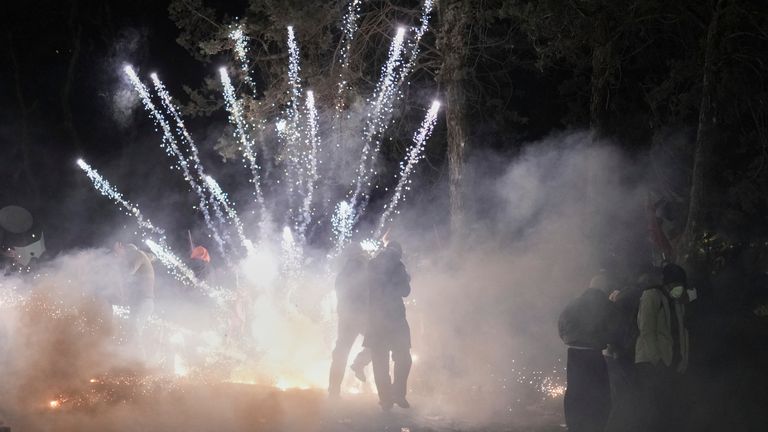 Ohňostroj spustil protestující, když se střetli s nepokoje policie během protestu proti zatčení starosty Istanbulu Ekrem Imamoglu, v Istanbulu, Turecko, sobotu 22. března 2025. (AP Photo/Francisco Seco)