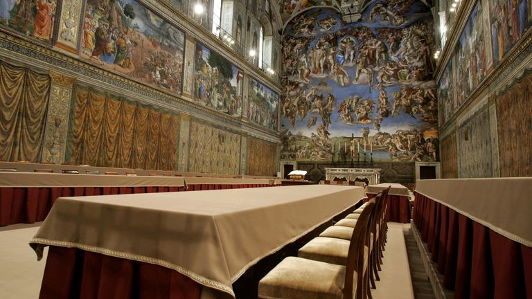 Nově nainstalované stoly pro příští týden konkláve stojan pod Michaelangelo's Frescoes ve Vatikánské sistinské kapli 16. dubna 2005. [When Roman Catholic cardinals vote in the Vatican for a new pope next week, they will swear an oath before God in Latin and then cast ballots written in the Church's official language.]