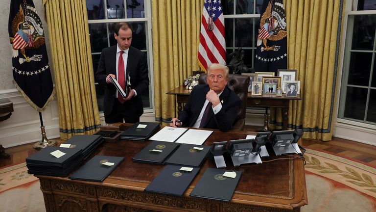 U.S. President Donald Trump signs documents as he issues executive orders and pardons for January 6 defendants in the Oval Office at the White House on Inauguration Day in Washington, U.S., January 20, 2025.  REUTERS/Carlos Barria