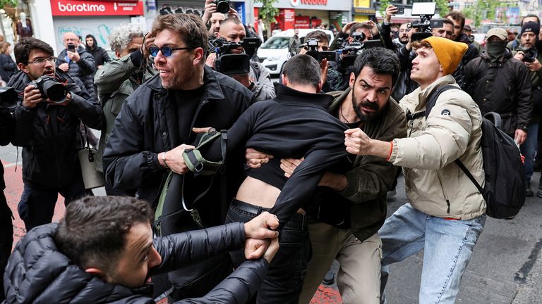 Členové policejního prostého obložení zadržují protestujícího, protože se lidé pokoušejí vzdorovat zákazu a pochodovat na náměstí Taksim na oslavu května v Istanbulu v Turecku 1. května 2025. Reuters/Umit Bektas