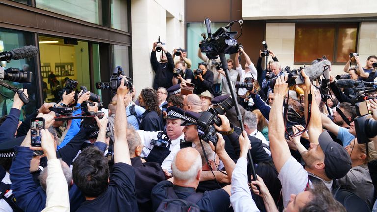Značka Russell obklopená médii, když dorazí k soudu Westminster Magistrates 'Court.  Pic: Reuters