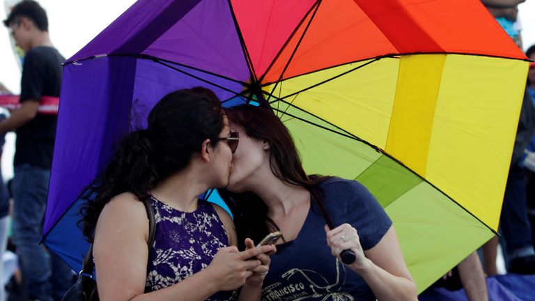 Homosexuální pár se navzájem políbí, když se tisíce katolíků a konzervativců shromažďují proti legalizaci homosexuálního manželství a aby bránili jejich interpretaci tradičních rodinných hodnot v Monterrey City v Mexiku 10. září 2016. Reuters/Daniel Becerril