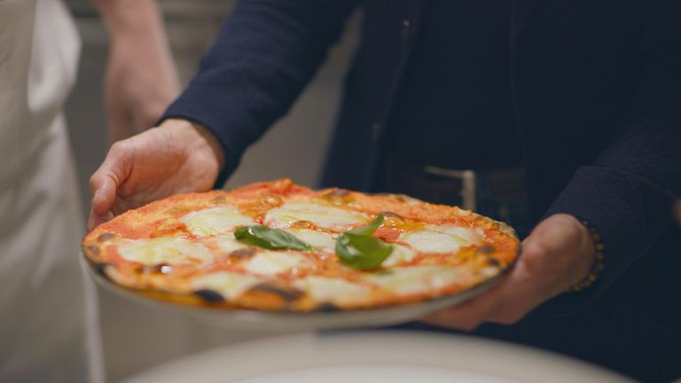 Ramadan El Sabawy ruce Stanley Tucci talíř s křupavou pizzou Margherita jeho syna. Pic: National Geographic