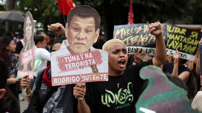 Muž drží znamení proti bývalému filipínskému prezidentovi Rodrigu Duterteovi během protestu v Manile na Filipínách v pátek. 28. března 2025. (AP Photo/Basilio Sepe)  