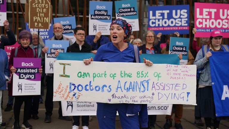 Doktor Geri Hignett protestuje proti změně zákona o asistovaném umírání, kromě protestujících prokazujících na podporu, mimo skotský parlament v Edinburghu, před debatou a hlasováním o asistovaném umírání pro vyléčení nemocných dospělých (Skotsko) později dnes. Datum obrázku: Úterý 13. května 2025.