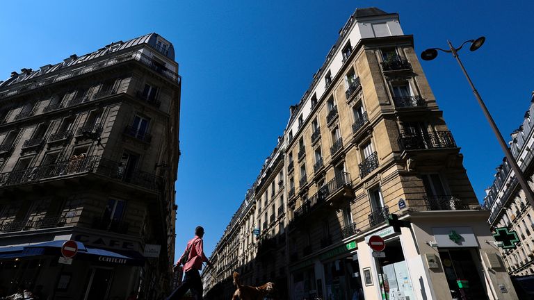 Žena prochází se svým psem na ulici Rue Pache, poblíž místa, kde se maskovaný gang pokusil unést dceru krypto podnikatele v Paříži, 14. května 2025. Reuters/Gonzalo Fuentes