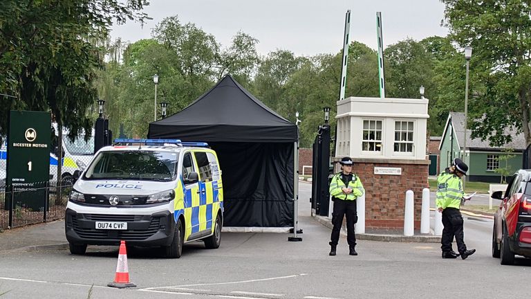 Policejní kordon poblíž místa požáru v Bicesteru v Oxfordshiru, kde zemřeli dva hasiči a veřejnost a dva hasiči byli také vážně zraněni. Ve čtvrtek vypukl velký oheň na místě bývalé základny RAF, která je domovem pro více než 50 specializovaných podniků zaměřených na klasické restaurování a inženýrství automobilů. Datum obrázku: Sobota 17. května 2025.