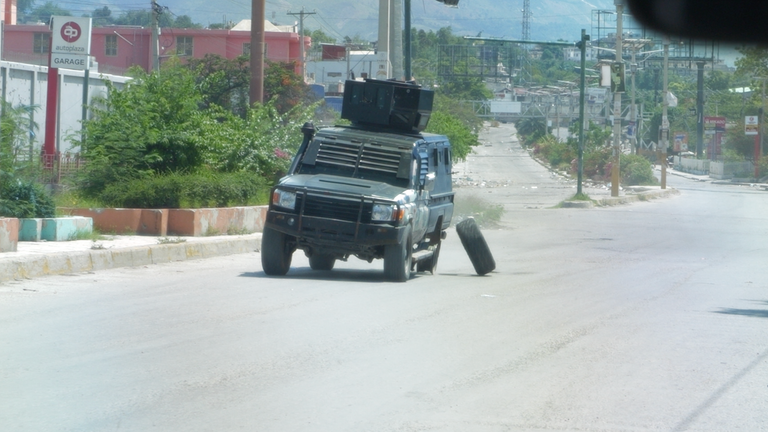 Pneumatika spadne z policejního automobilu, které je propuštěno, port-au-prince, haiti pic poslaný týmem Ramsay pro Haiti Story 1 