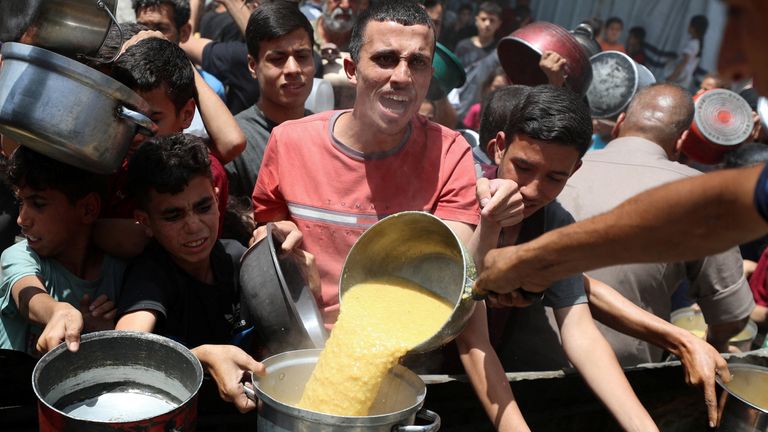 Palestinci čekají na přijetí jídla vařené charitativní kuchyní v Jabalia, v severním pásmu Gazy, 19. května 2025. Reuters/Mahmúd Issa