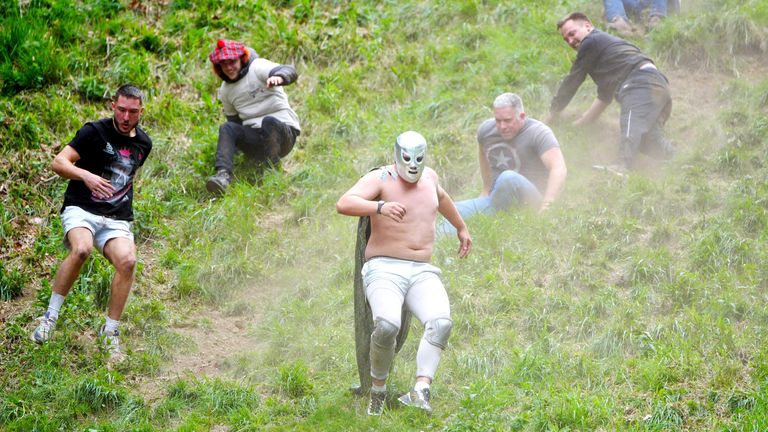 Účastníci se účastní každoročního válcování sýra na kopci Cooper's Hill v Brockworth v Gloucestershire.   Pic pa