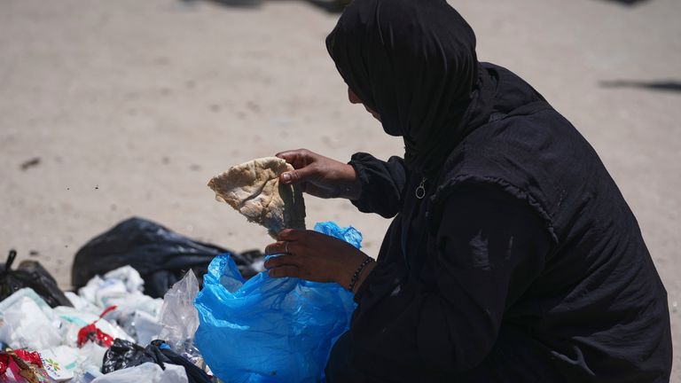Islám Abu Taeima najde kus chleba v hromadě odpadků ve městě Gazy. Pic: Ap.