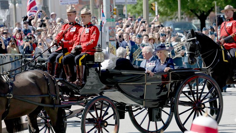 Král Charles a Queen Camilla jezdí v koňské Landau, doprovázené královskou kanadskou namontovanou policií.  Pic: Reuters
