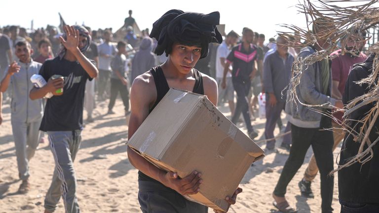 Palestinci nesou krabice obsahující balíčky potravin a humanitární pomoci dodávané Humanitární nadací Gazy, organizací podporovanou USA schválenou Izraelem v Rafahu.  Pic: Ap