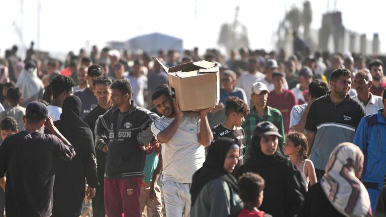 Palestinci nesou pomocné krabice obsahující balíčky potravin a humanitární pomoci dodávané Humanitární nadací Gazy, organizací podporovanou USA v Rafahu.  Pic: Ap