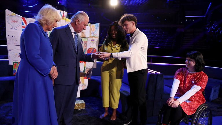 Král Charles a Camilla se setkávají s přednášejícími Blue Petra, když jsou předkládáni se svými odznaky. Pic: Ap