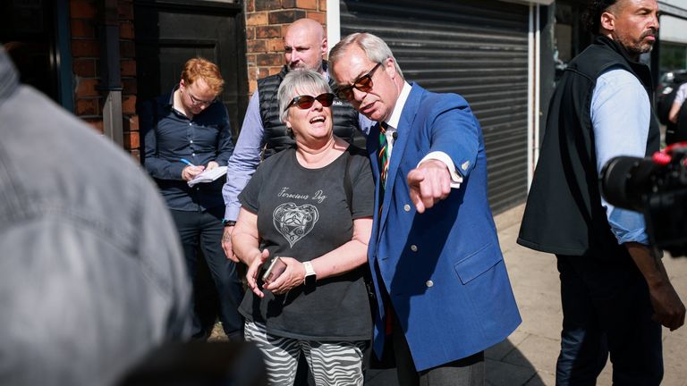 Nigel Farage reaguje vedle místního ve Scunthorpe.  Pic: Reuters