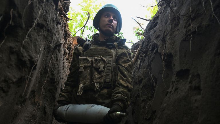 Serviceman ze 141. samostatné mechanizované brigády ukrajinských ozbrojených sil nese dělostřeleckou skořápku, než vystřelí na ruské jednotky, na pozici v první linii, uprostřed ruského útoku na Ukrajinu v oblasti Doněcku v Ukrajině 13. května 2025. Reuters/Stringer.