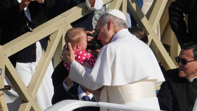 Papež Leo XIV je předán dítěti, když se vydává na inaugurační mši. Pic: Ap
