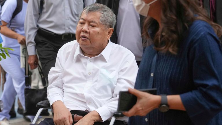 Premchai Karnasuta, prezident italské thajské rozvojové CO, dorazí na invalidní vozík na policejní stanici Bang Sue v Bangkoku v Thajsku v pátek 16. května 2025, aby se vzdal policii za trestnou nedbalost za kolaps výškové výškové lodi Bangkok během zemětřesení 28. března. (AP Photo/Sakchai Lalit)