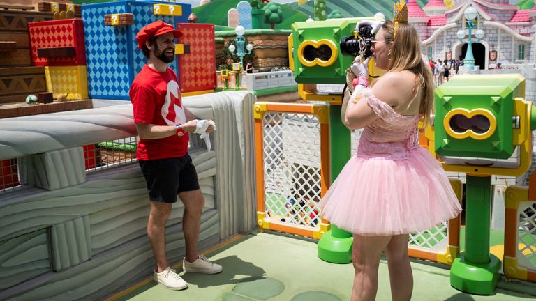 Muž nosí kostým Mario, když pózuje na fotografii "Super Nintendo World" Svět v zábavním parku Universal Epic Universe před slavnostním zahájením v Orlandu na Floridě, USA 20. května 2025. Reuters/Marco Bello/File Photo