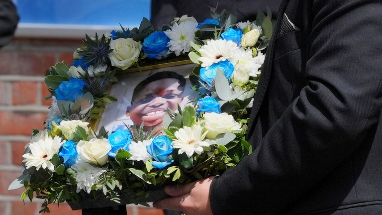 Květinový pocta s fotografií Daniela Anjorina, 14, po jeho pohřbu v Ilfordu ve východním Londýně v květnu 2024. Pic: Reuters. 