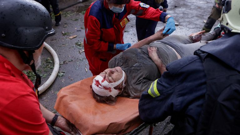Záchranáři a zdravotníci nesou zraněného obyvatele poté, co byla osvobozena od trosek v Charkivu.  Pic: Reuters/Sofiia Gatilova