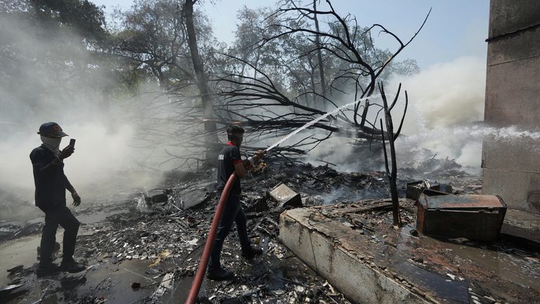 Hasiči pracují v místě letadla, které havarovalo v indickém severozápadním městě Ahmedabad ve státě Gujarat, Indie, čtvrtek 12. června 2025. (AP Photo/Ajit Solanki)