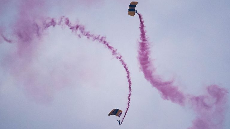 Vojenští parašutisté vydávají červený kouř, když sestupují. Pic: Reuters