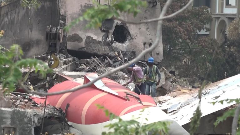 Muži pracují na vyčištění ruin Air India Boeing 787 Dreamliner poté, co to havarovalo