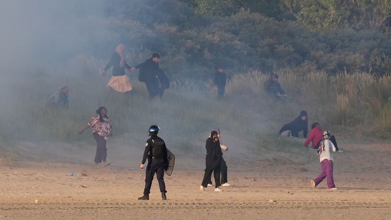 Lidé považovali za migranty, kteří se vynoří z keřů na pláži ve Francii ve Francii poté, co francouzské úřady vypálily slznou plyn. Datum obrázku